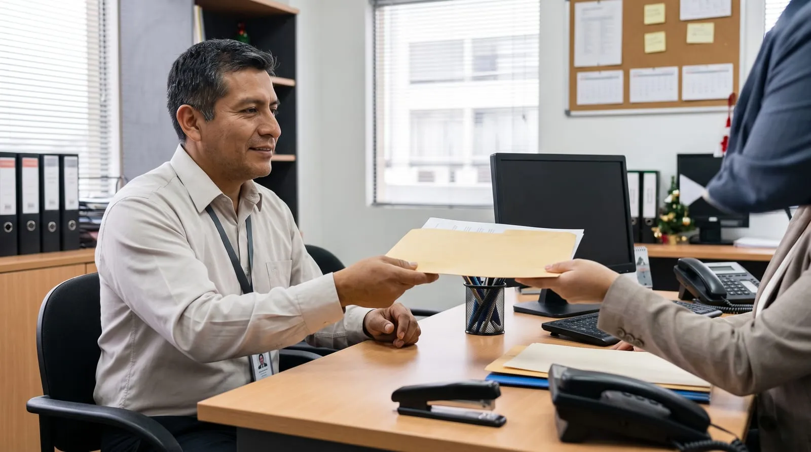 Trabajador recibe un sobre con documentos en el área de recursos humanos